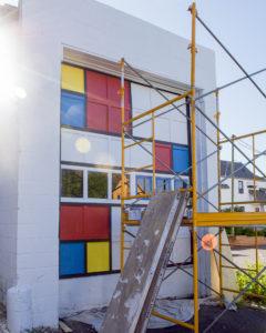 Mid-progress of mural project. Marquette artist Taryn Okesson is nearing completion of mural. Mondrian Garage Mural Third Street, Marquette, MI.